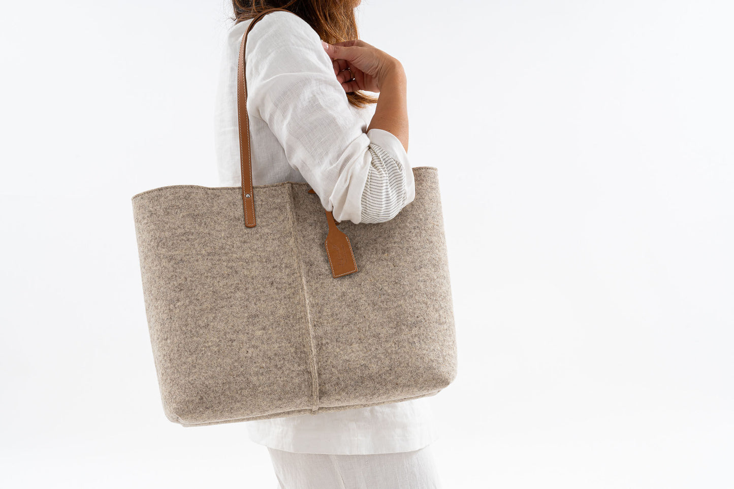 Tote Bag Large Beige made of Merino wool felt and vegan leather, featuring two large internal pockets, perfect for work or a day out. Soft, sturdy, and roomy without being bulky, with a large opening and internal magnetic buttons for easy access and security. Handmade in Italy.