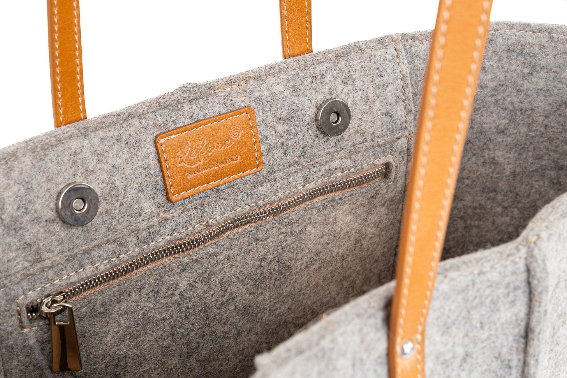 Tote Bag Large Grey made of 3mm Merino wool felt with vegan leather accents. Features include two internal pockets (one zippered, one open), a 27 cm handle drop, and a pendant with the Lefrac logo. Fits laptops up to 13”, tablets, and e-readers. Comes with a natural cotton dust bag. Handmade in Italy. - Lefrac