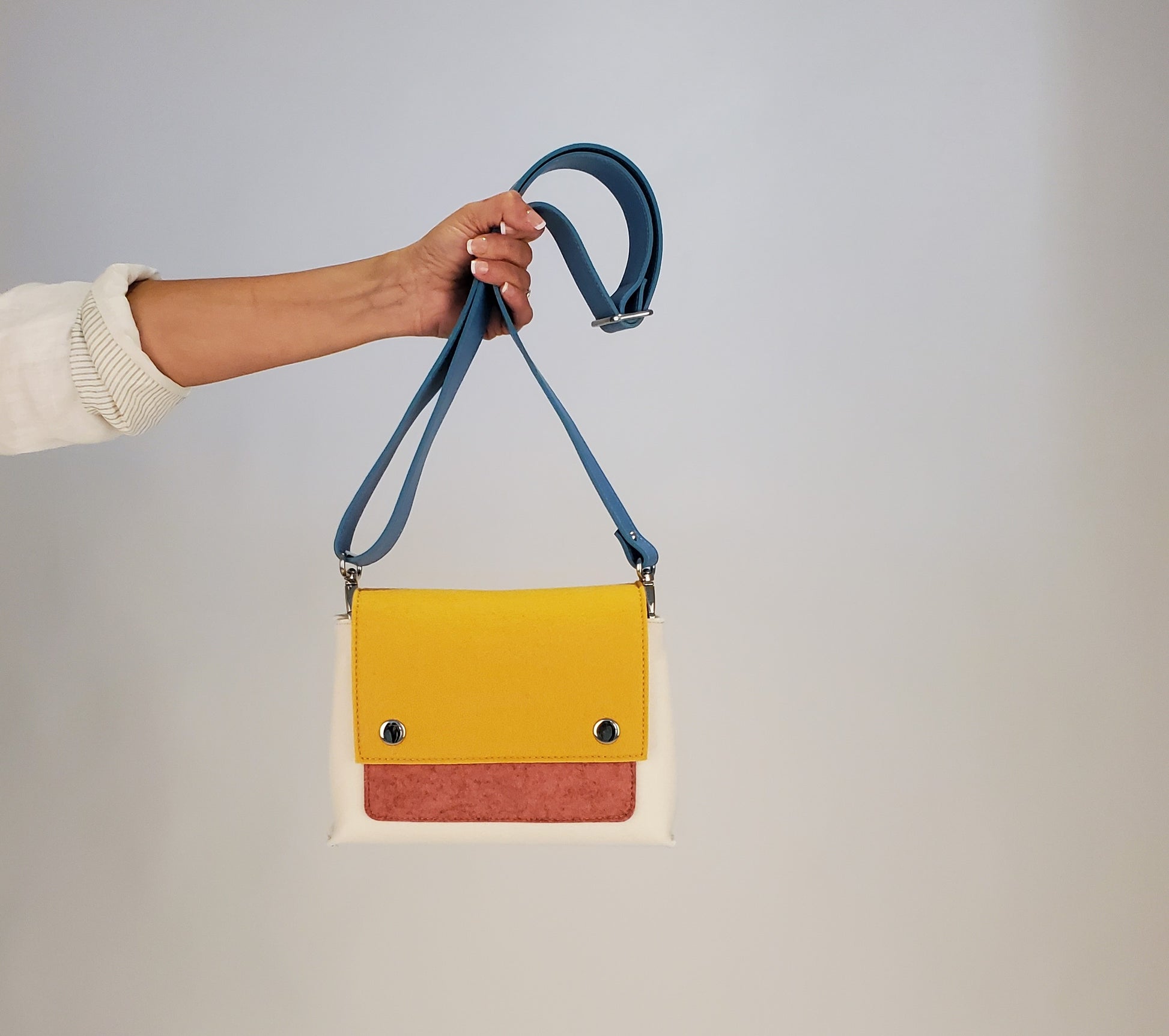 JOY Yellow Multi-Color Crossbody Bag: Small, ergonomic, and fun with vibrant hues. Features 3 pockets (2 external, 1 internal), adjustable strap, flap closure with magnetic buttons. Made from durable Merino wool felt and eco-friendly vegan leather. Handmade in Italy with unique, vintage look.